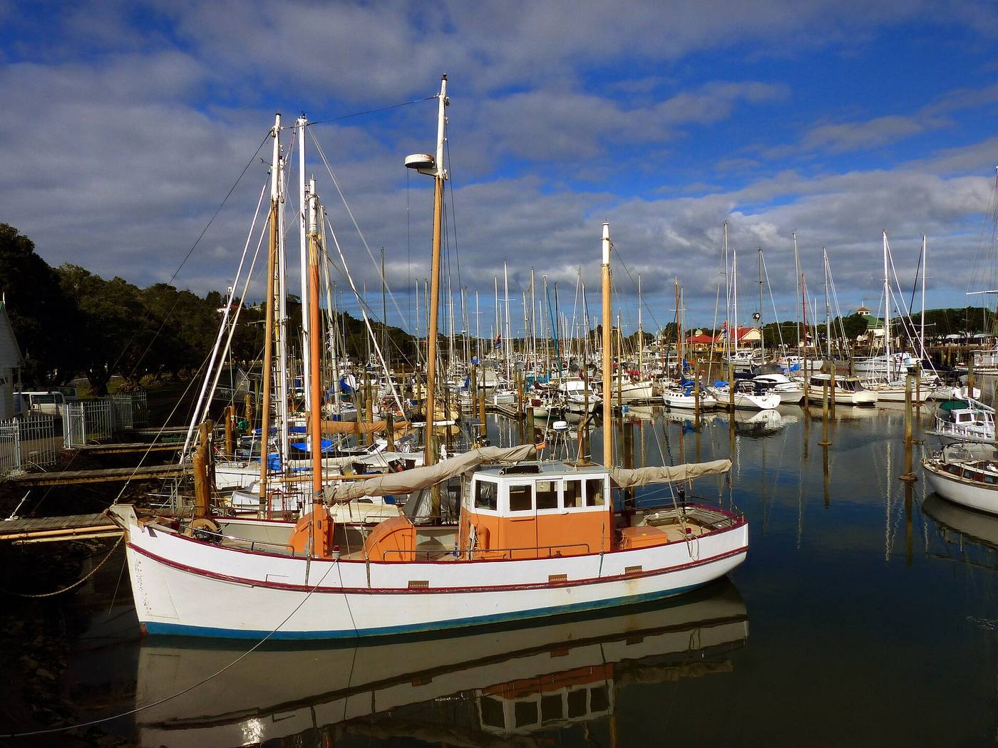 Boats moored at Whangarei marina, masts against the hills behind